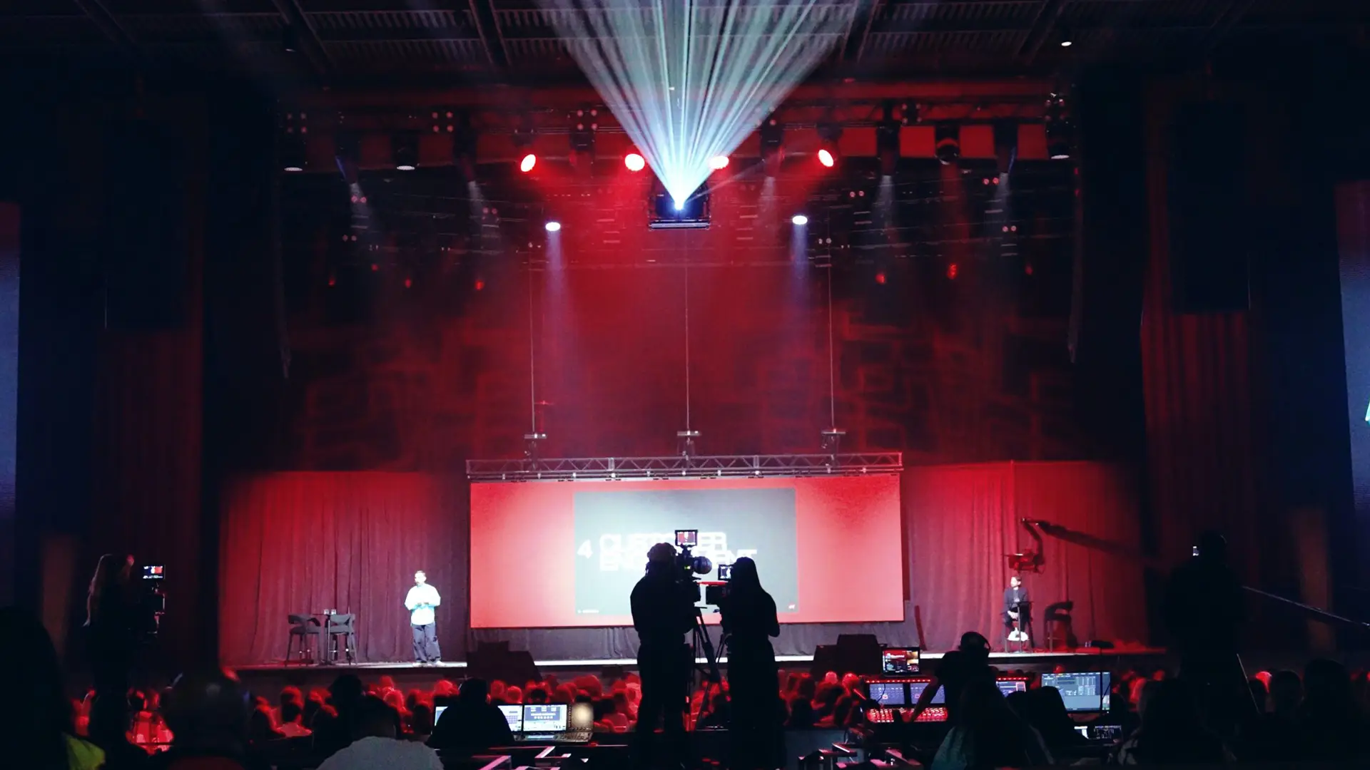 H&M 88 View from behind of crew filming a man on stage