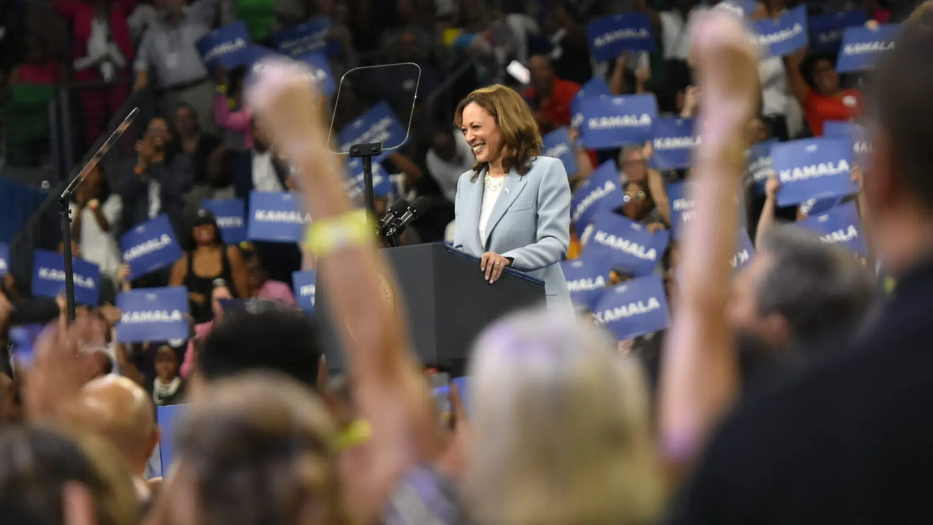 Kamala Harris 10 Kamala Harris speaking in front of crowd waving placards