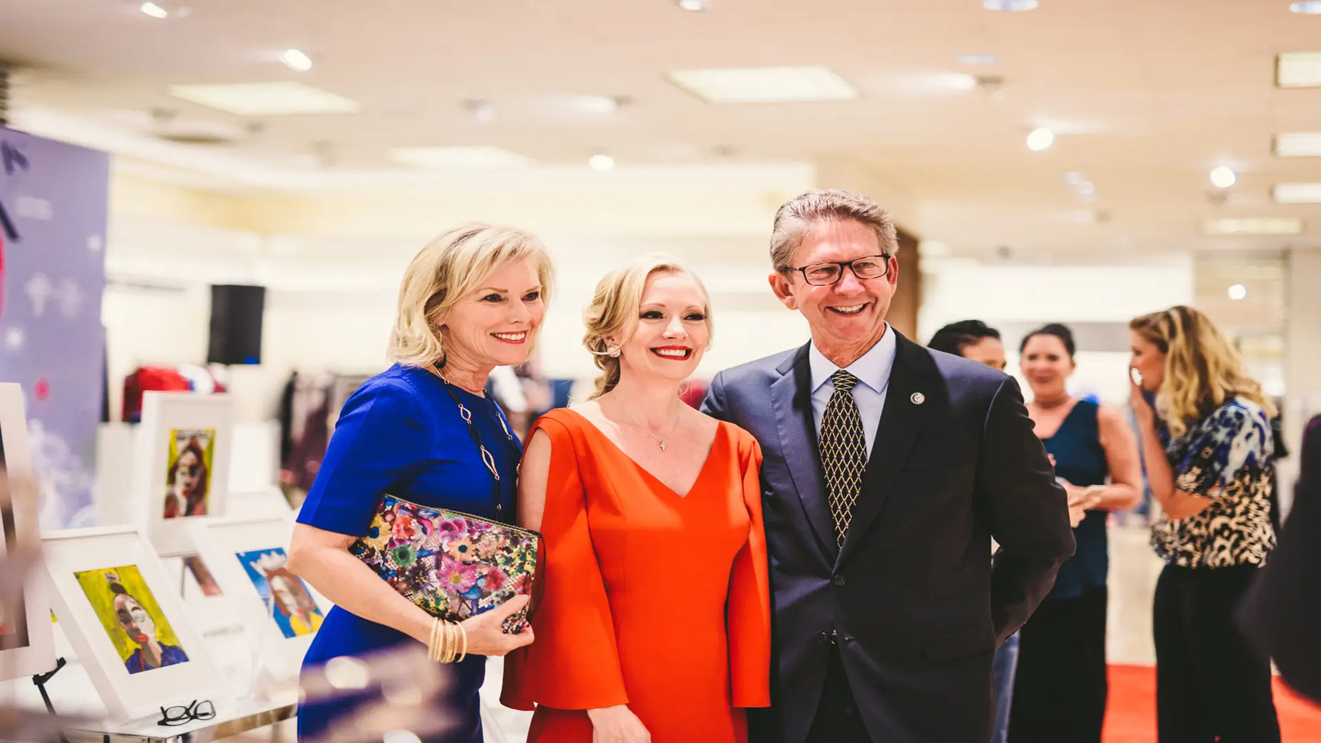 Neiman Marcus 13 Woman dressed in red standing next to man and woman