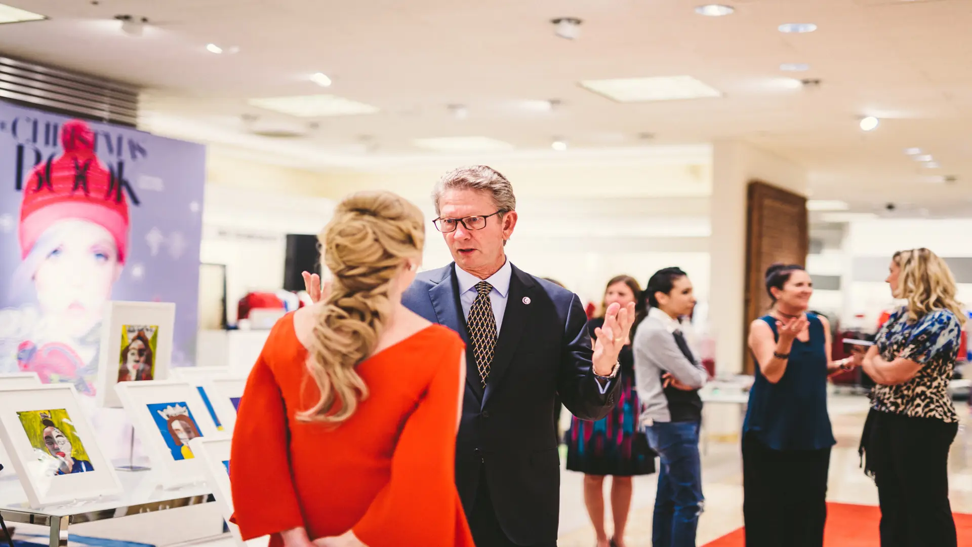 Neiman Marcus 16 Man talking with woman with a few people behind them