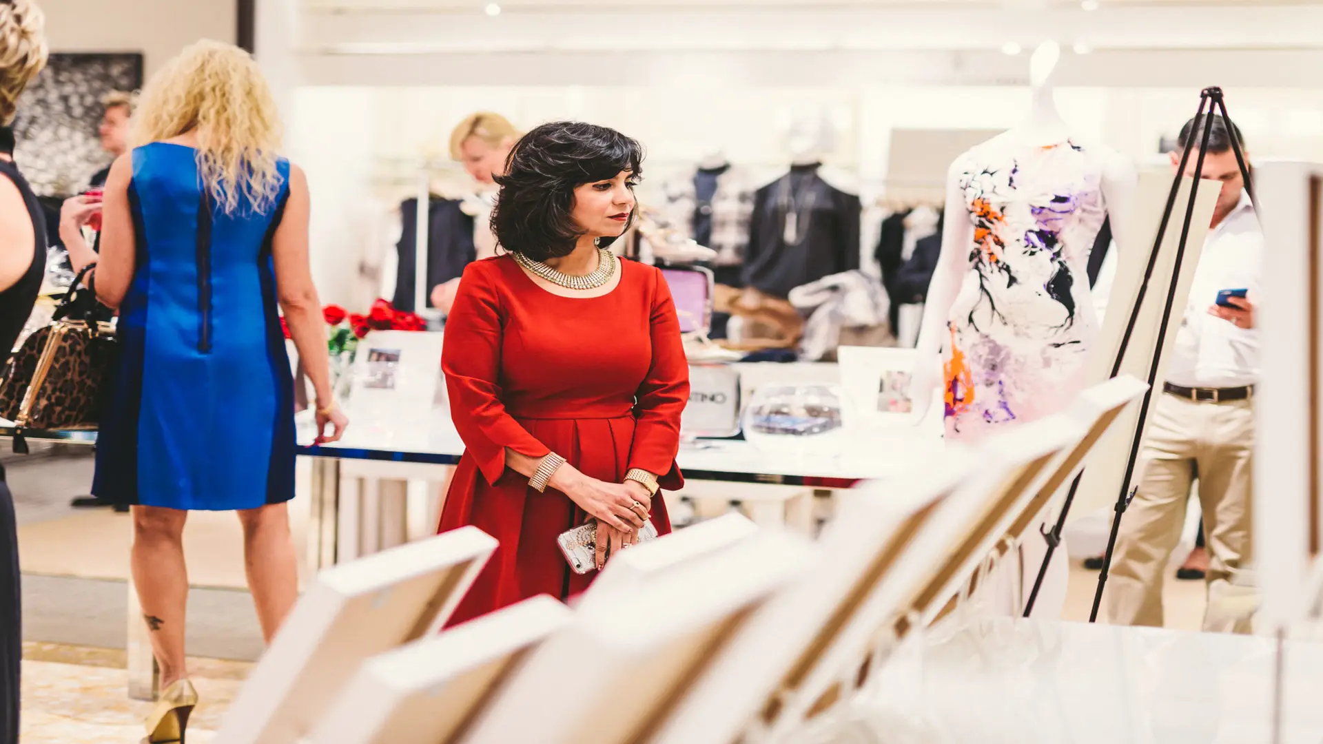 Neiman Marcus 19 Woman dressed in red browsing with woman dressed in blue behind her