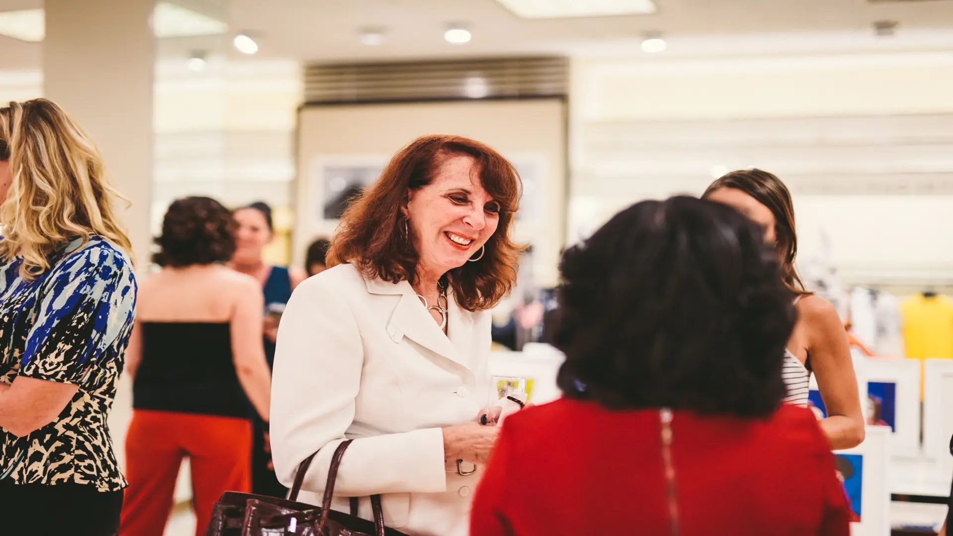 Neiman Marcus 21 Three women talking with others around
