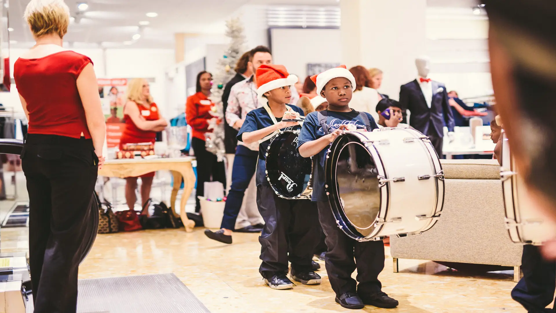 Neiman Marcus 5 Two boys with drums wait with people around them
