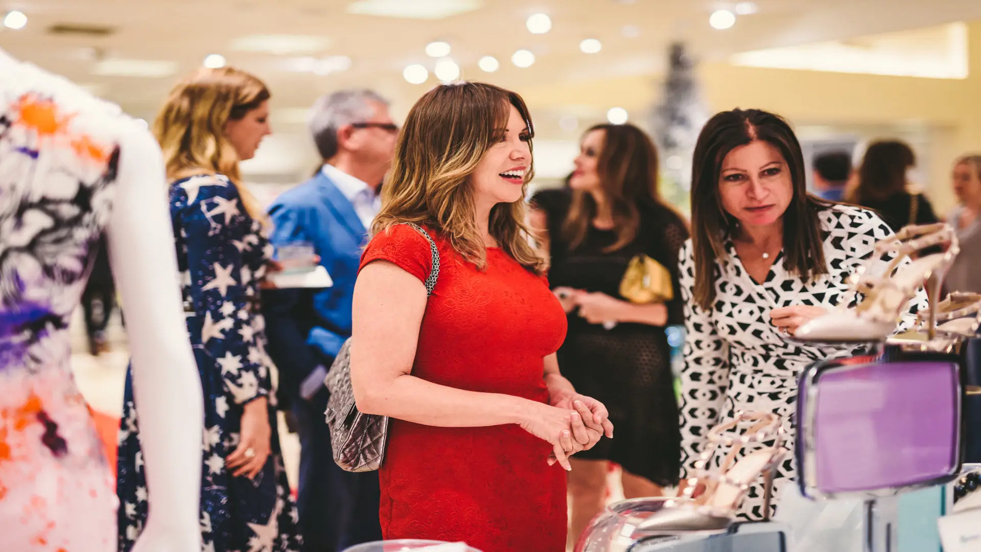 Neiman Marcus 24 two women browsing with others around
