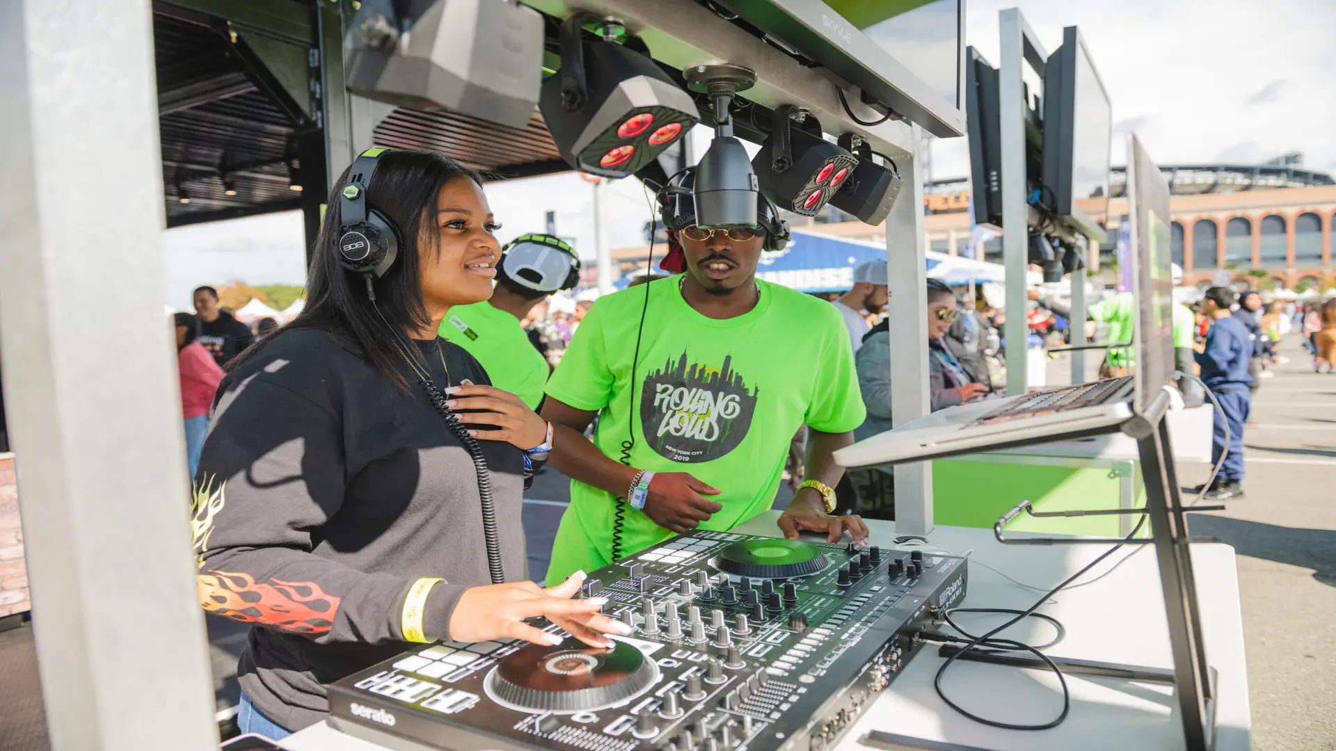 Rolling Loud 18 Man wearing outfit next to woman being a disc jockey