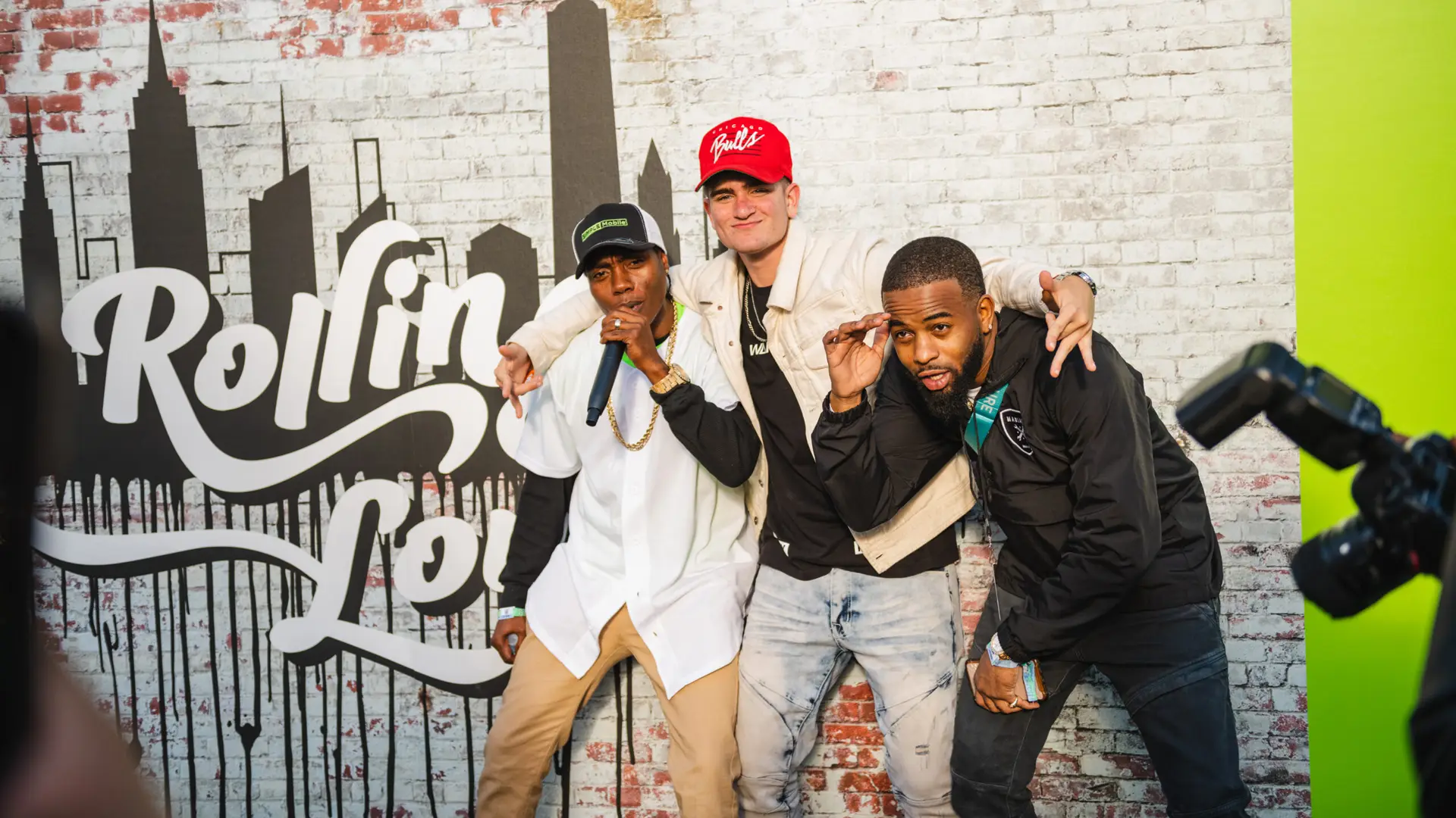 Rolling Loud 6 Three men posing for the camera in front of mural