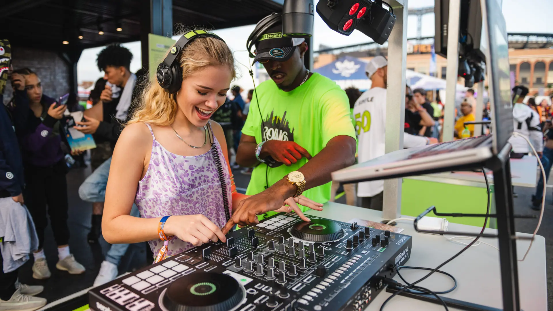 Rolling Loud 7 Man showing woman both wearing headphones how to be a disc jockey