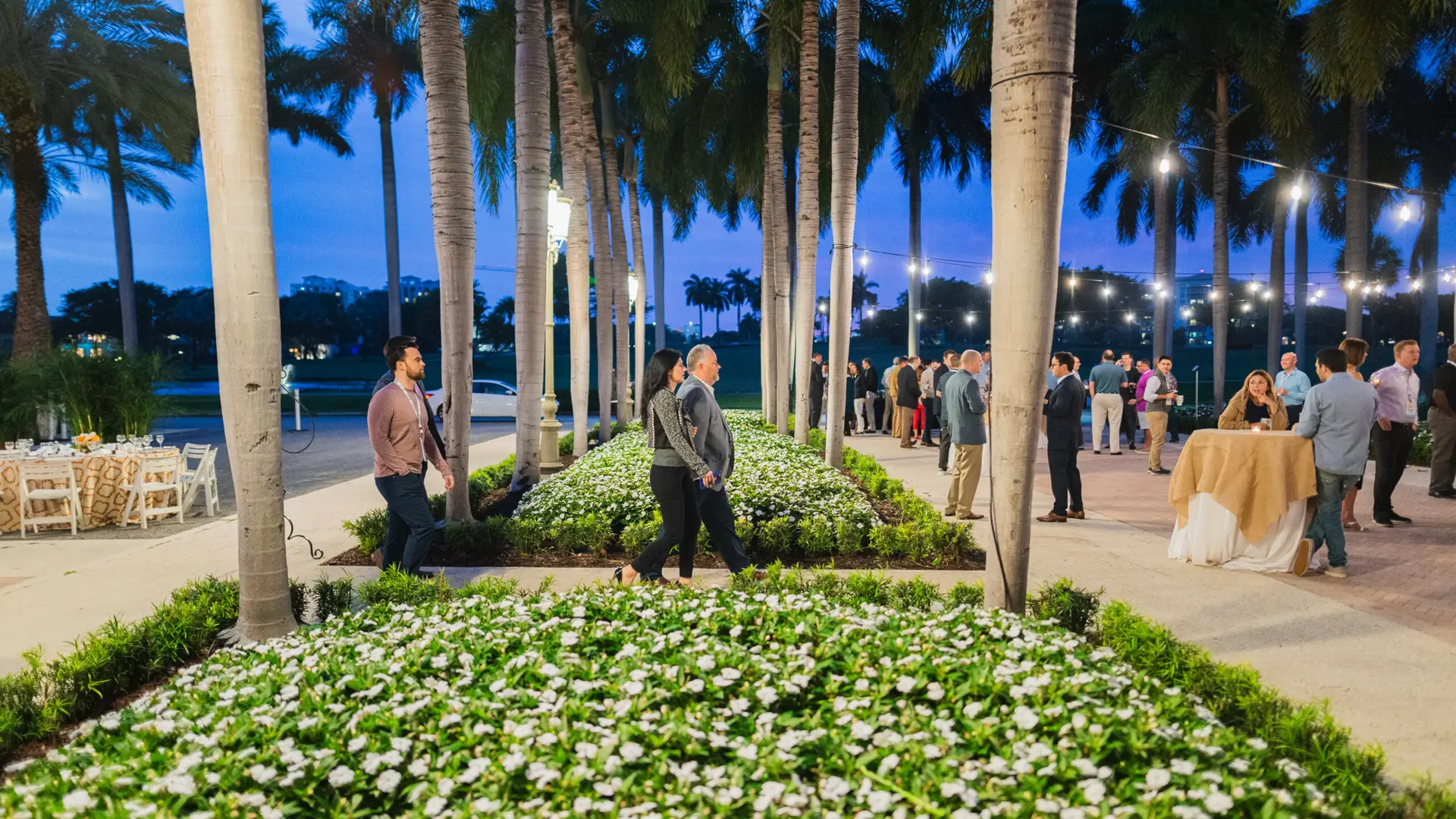 SFBTA 30 People walking around courtyard with palm trees, tables and chairs