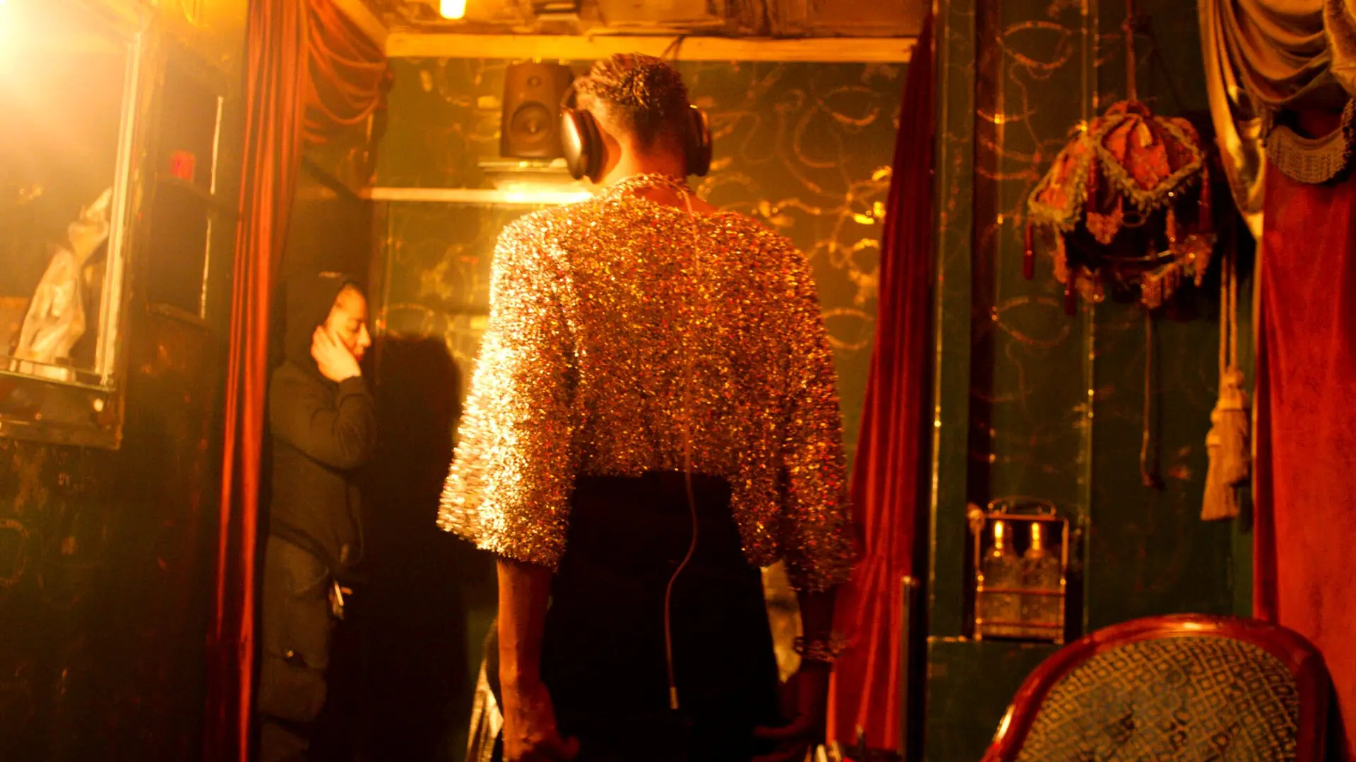 Billy Porter wearing headphones in recording studio from behind