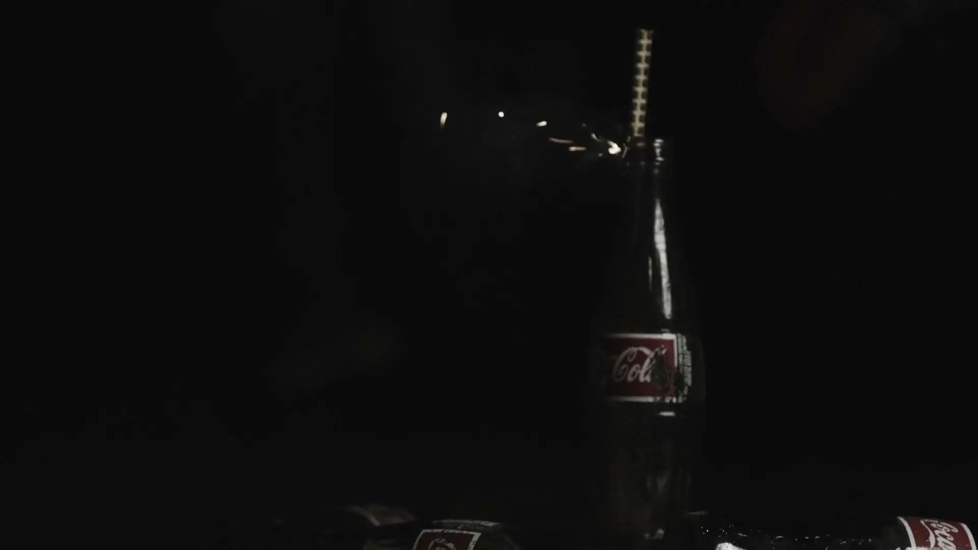 Coca-Cola 6 Coca-Cola glass bottle with lit sparkler fuse closeup