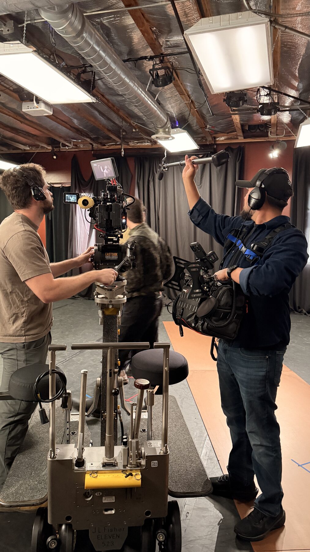 The Loudest Voice 9 Boom operator reaching over the camera during a studio setup