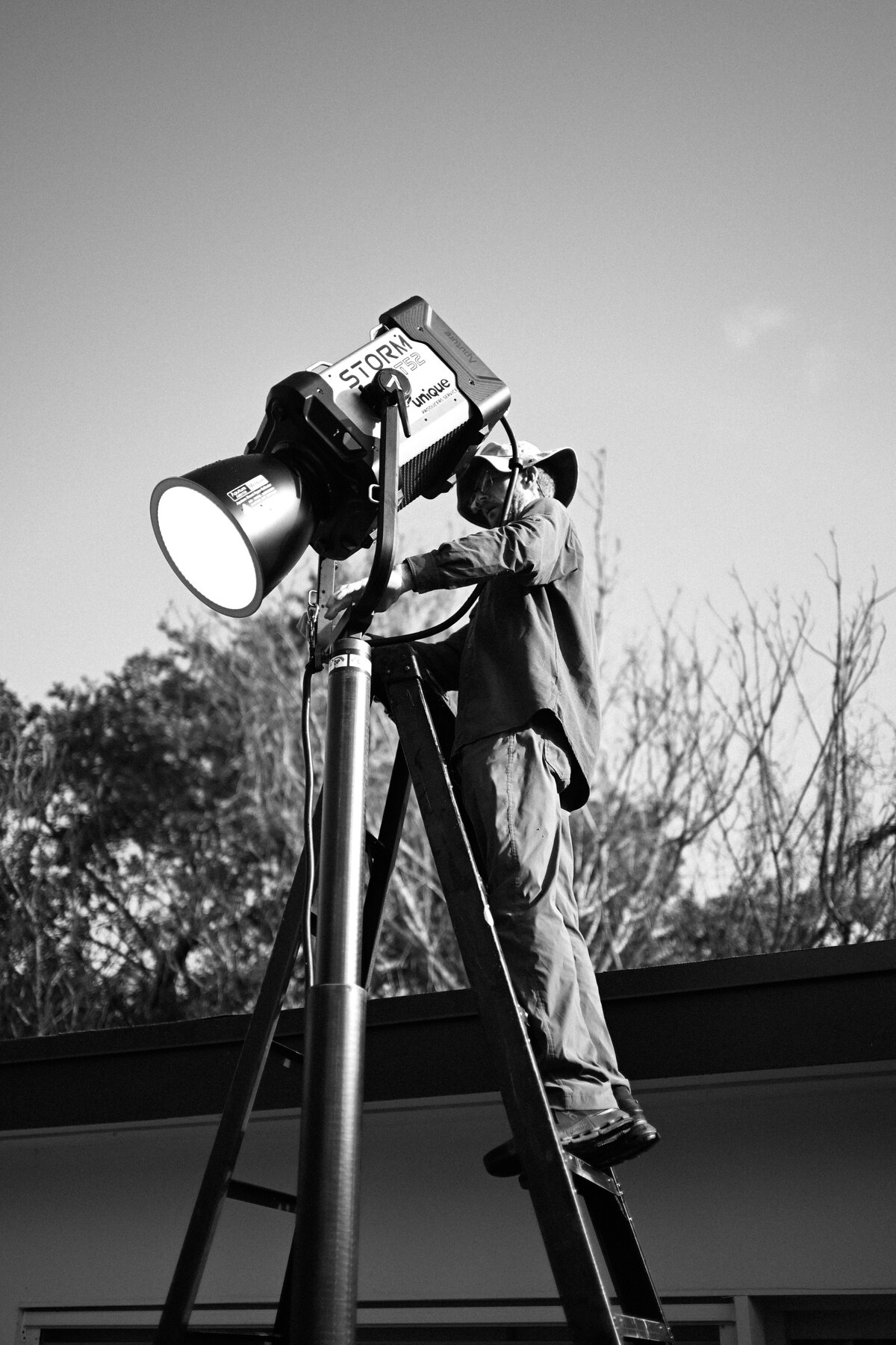 BeatBot 25 Gaffer rigging a light above the pool on the BeatBot product launch video production