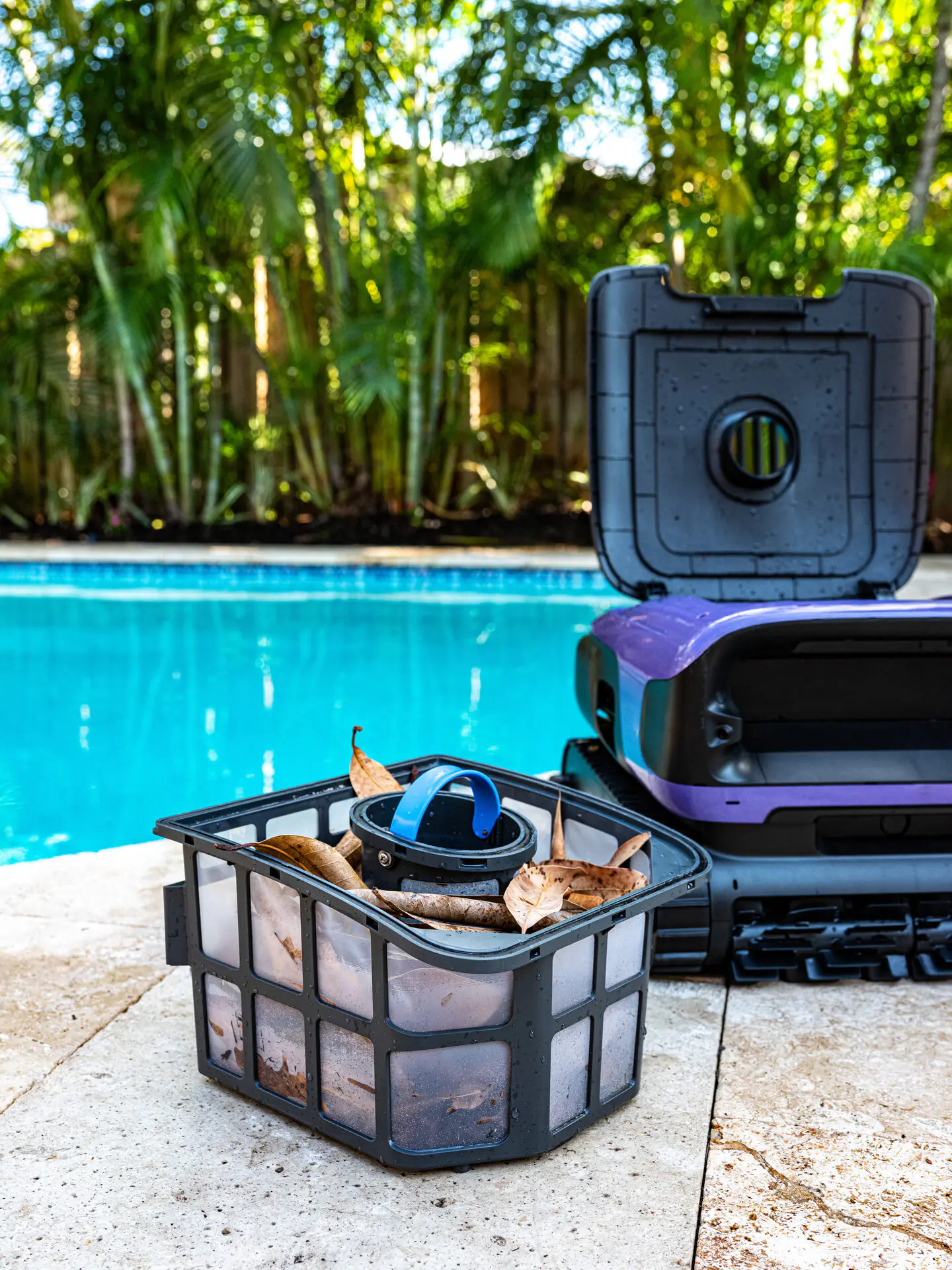 BeatBot 10 BeatBot Sora 70 debris basket filled with leaves beside the pool