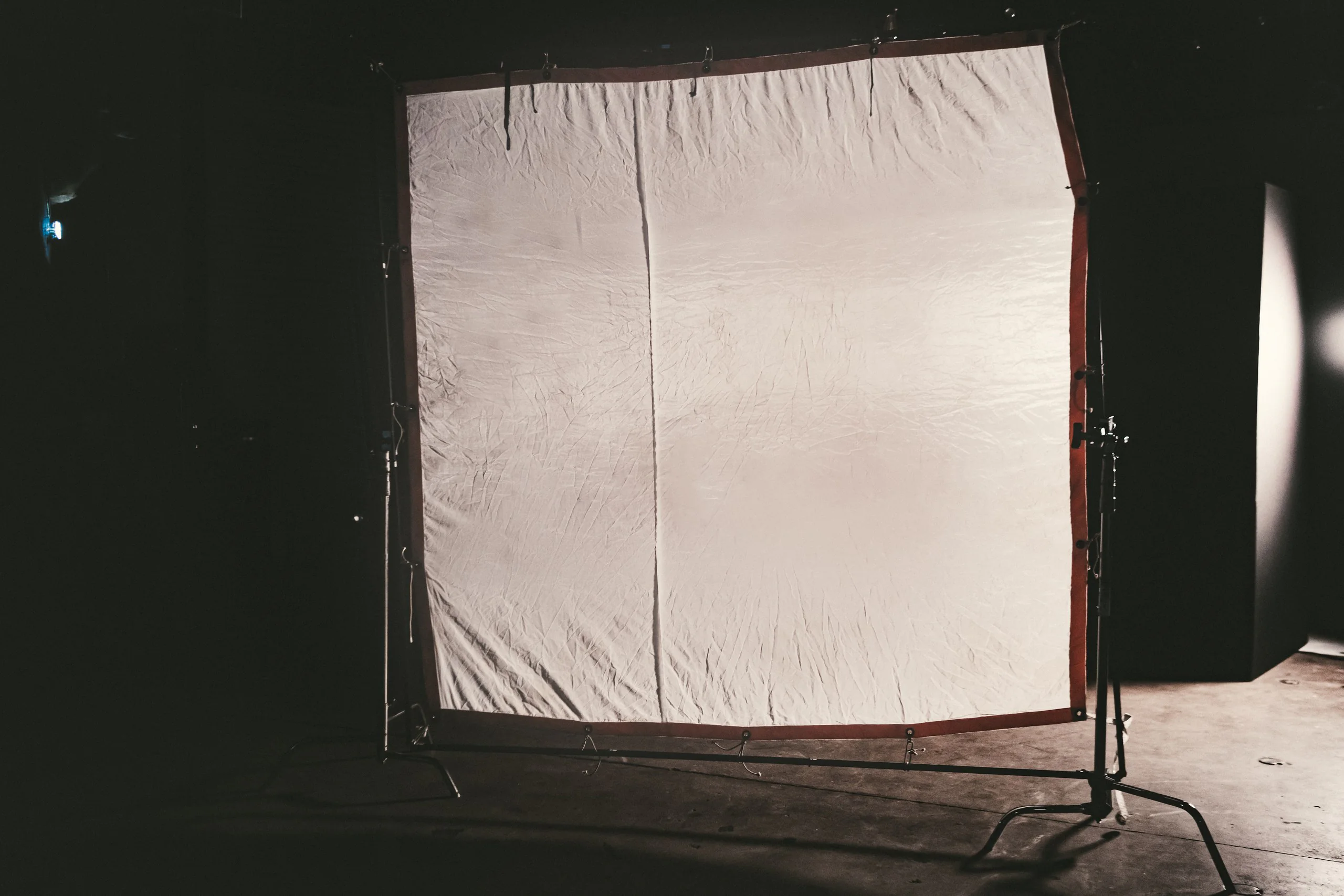 Production Gear 13 Large diffusion frame rigged on stands across a darkened studio stage