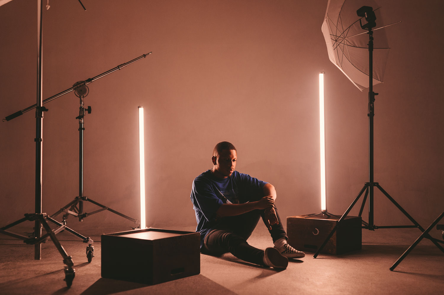 Lighting 17 Portrait lit with tube practicals standing in frame beside stands and an umbrella
