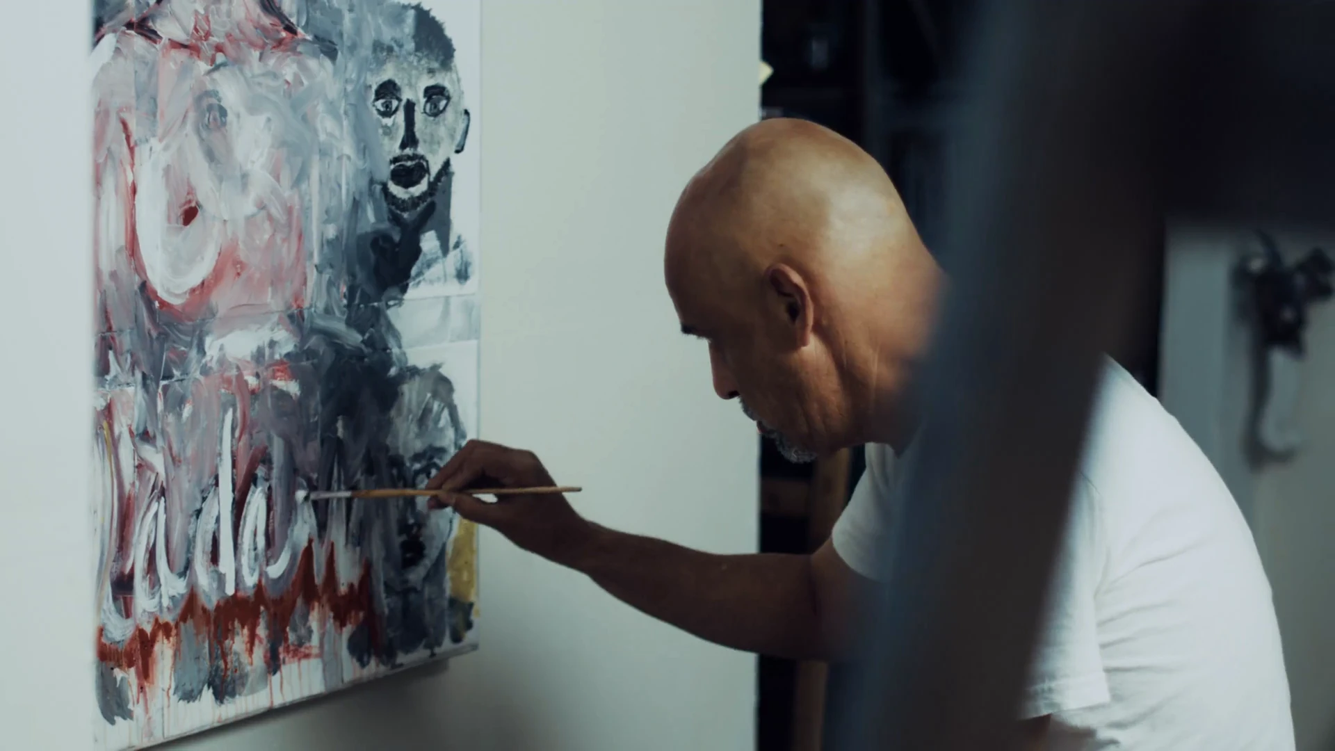 The artist working on a canvas in his studio