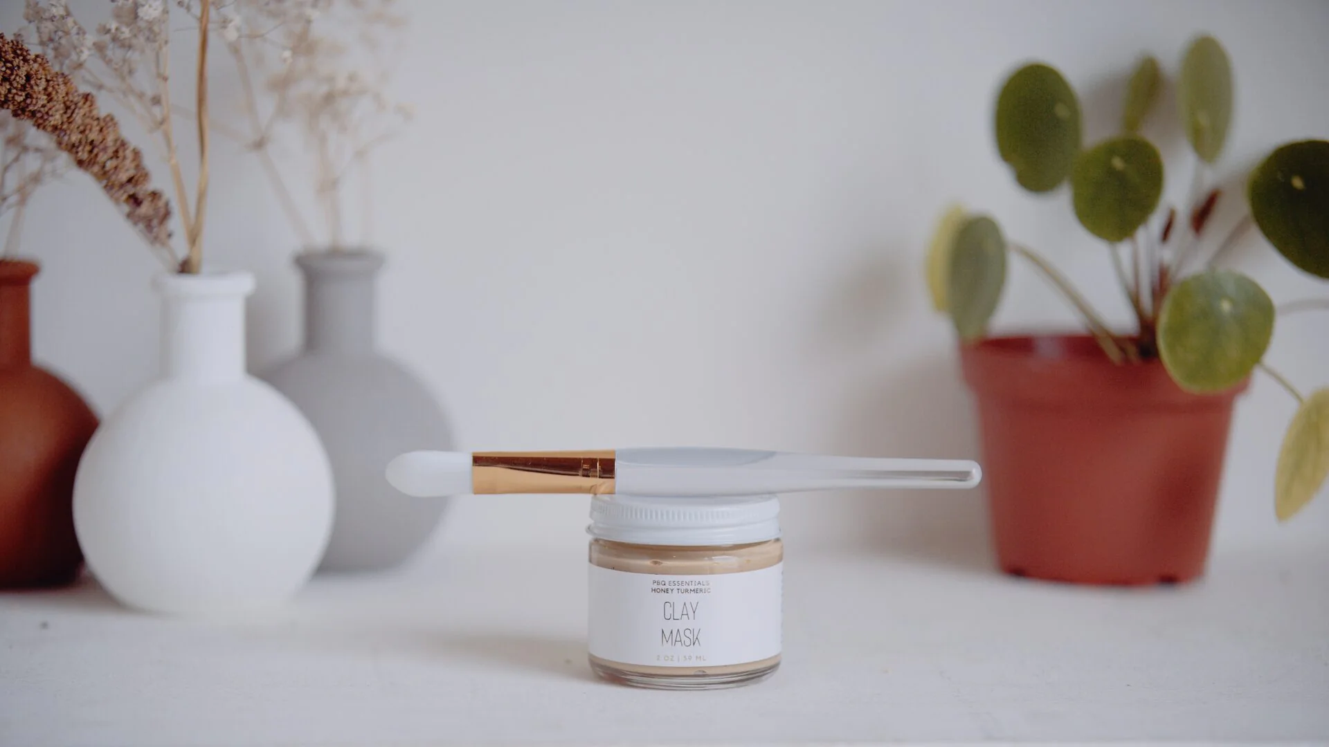 Beauty product still life of a clay mask jar with a spatula