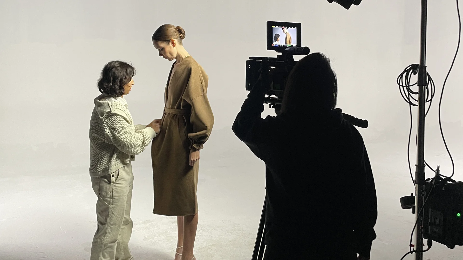 Product Photography 13 Stylist adjusting a model's coat on a white cyc during a C&I Studios photo shoot