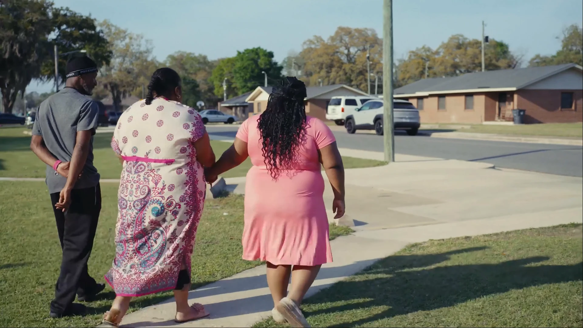 Family walking hand in hand down a neighborhood sidewalk in Southwest Georgia